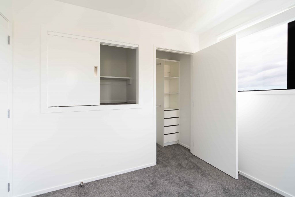 compress.2_Jadewynn-IMG-Interior-24 Built-in cupboards and open shelving beside a walk-in wardrobe with drawers and a hanging rail.
